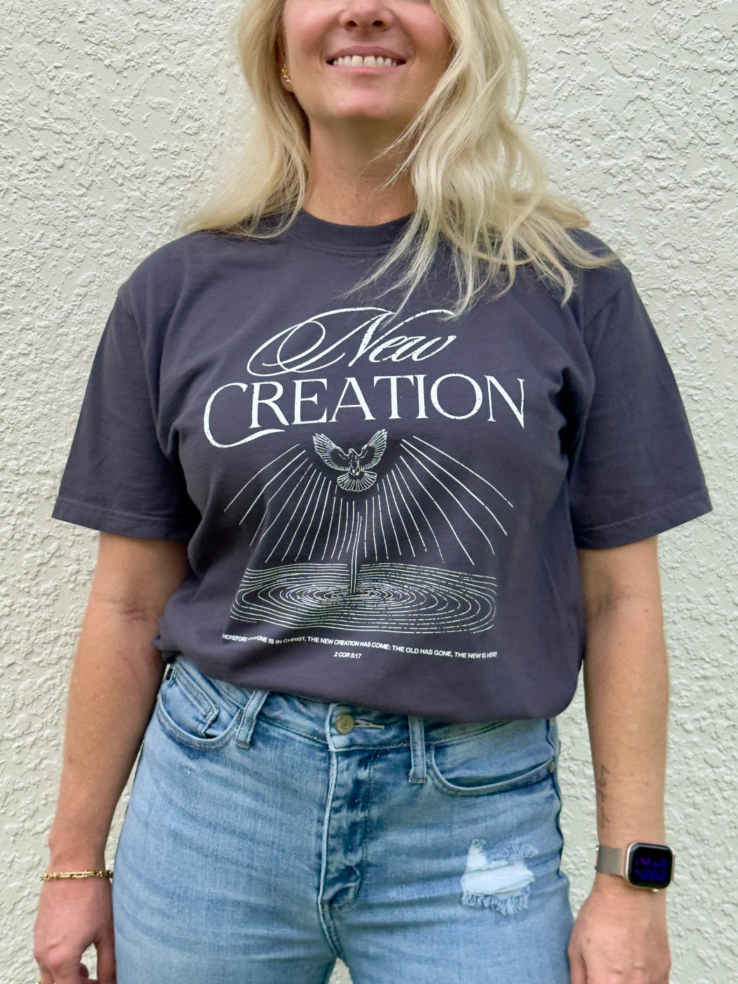 Woman wearing New Creation 2 Corinthians 5:17 Christian t-shirt in Comfort Colors charcoal